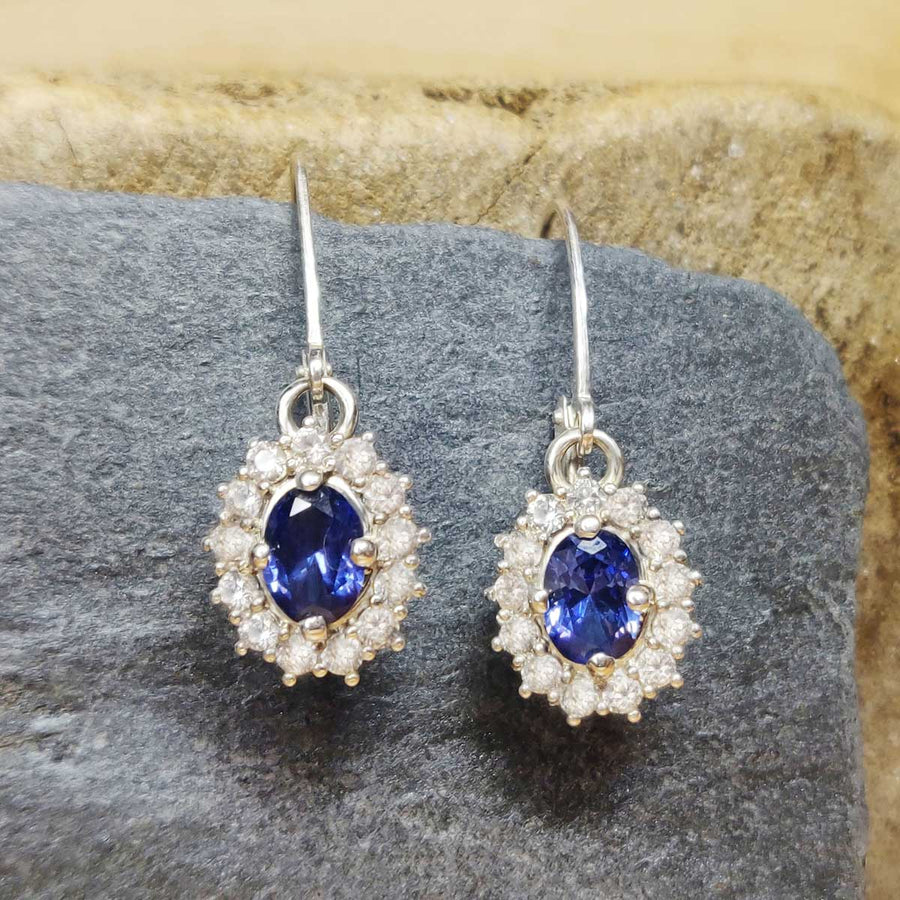 Blue and white sapphire cluster earrings in argentium silver on wooden background
