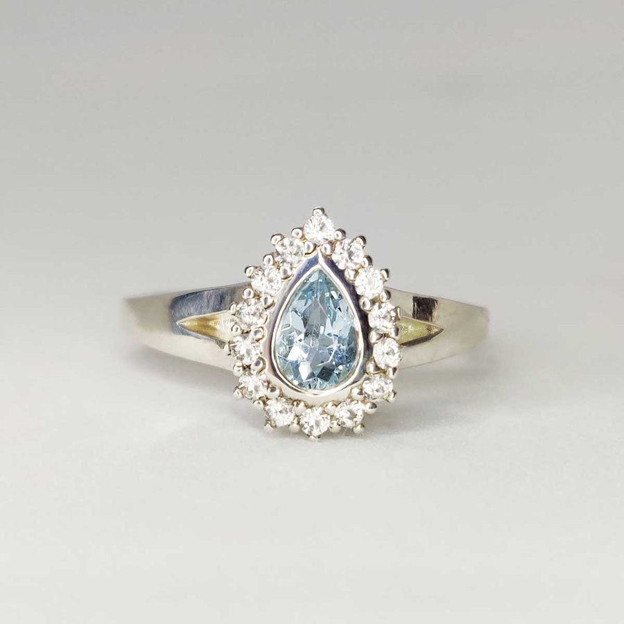 Pear cut aquamarine and white sapphire cluster ring in argentium silver on white background