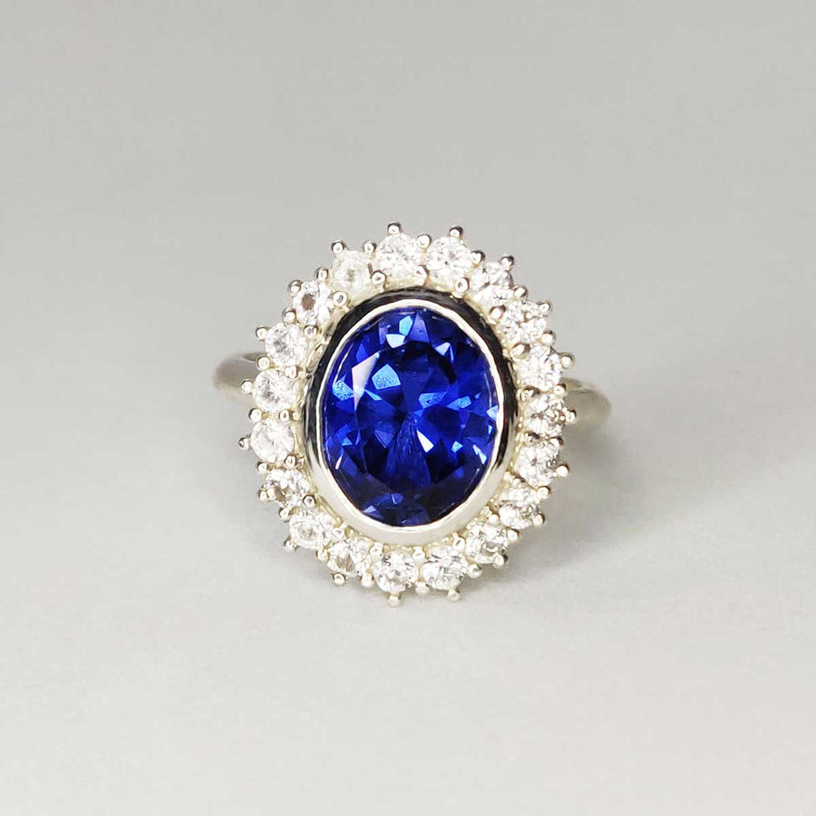 Blue and white sapphire cluster ring in argentium silver on white background