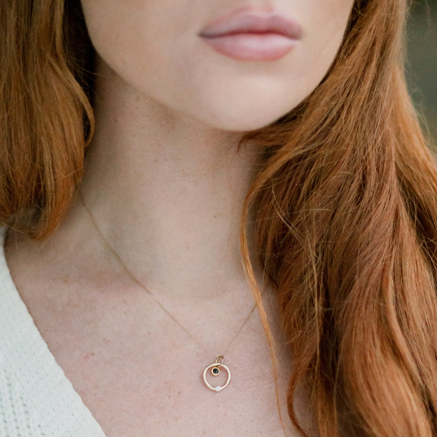 Model wearing gold and diamond hoop pendant