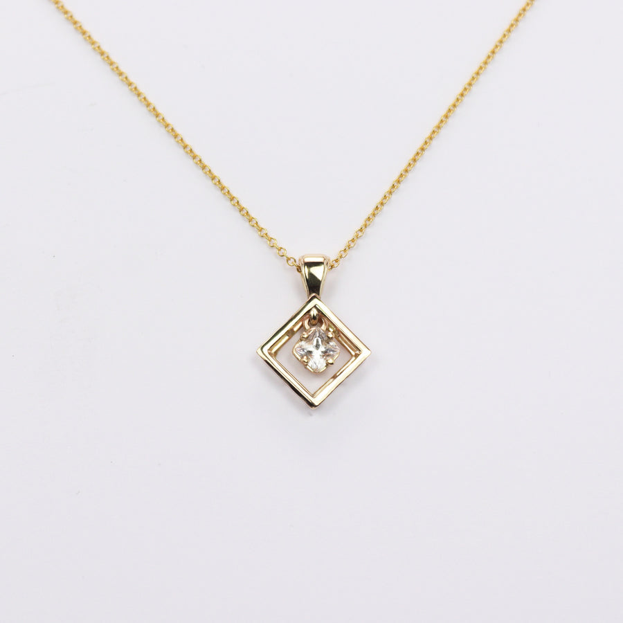 White princess cut sapphire pendant on a solid gold chain on a white background.