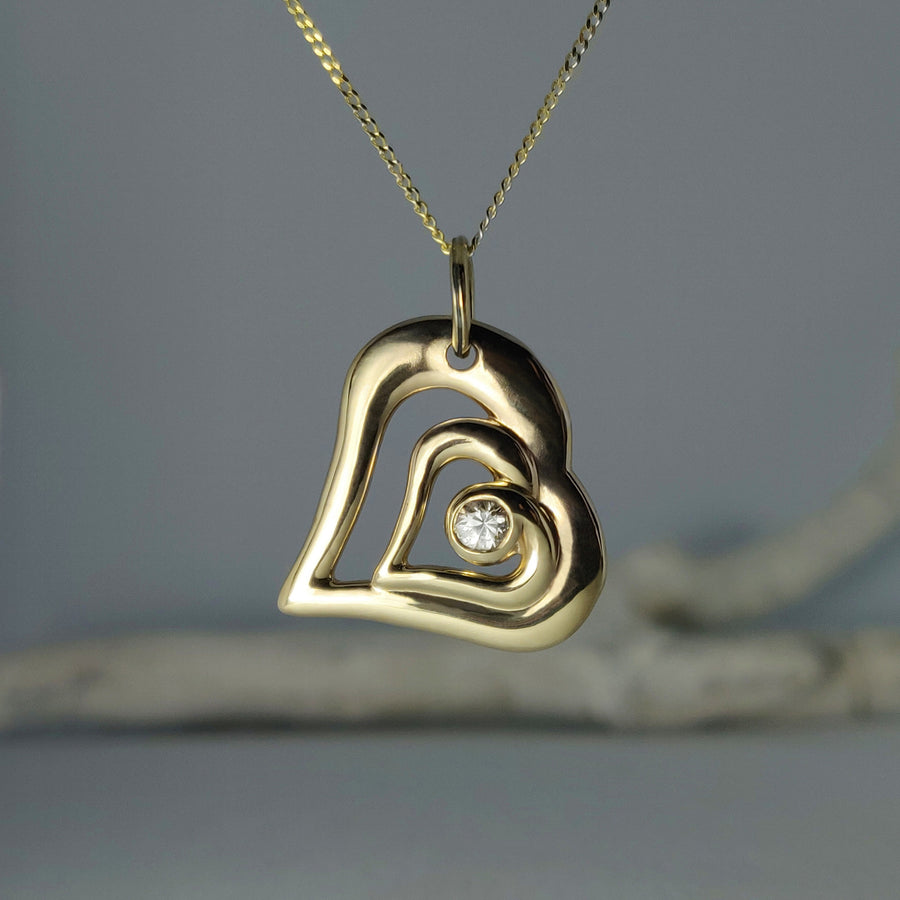 Gold heart diamond necklace. Mothers day gift against a white background.