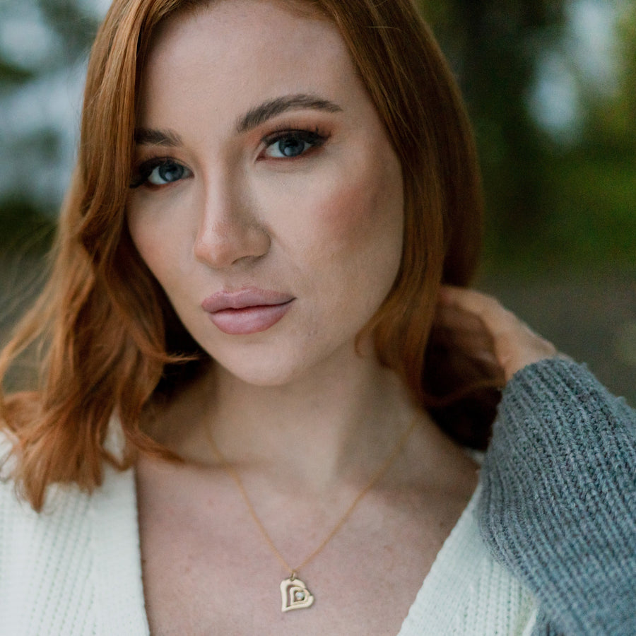 Model wearing a diamond acushla two hearts necklace.