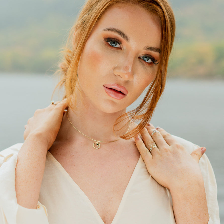 Girl in front of a loch wearing a Solasta Omega Diamond and Sapphire Gold Necklace