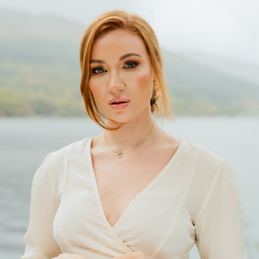 Front view of a model wearing a Solasta Omega Diamond and Sapphire Gold Necklace