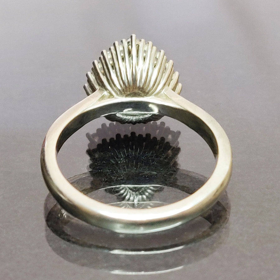 Rear view of a trillion cut citrine and white sapphire halo cluster pave ring on a reflective surface.