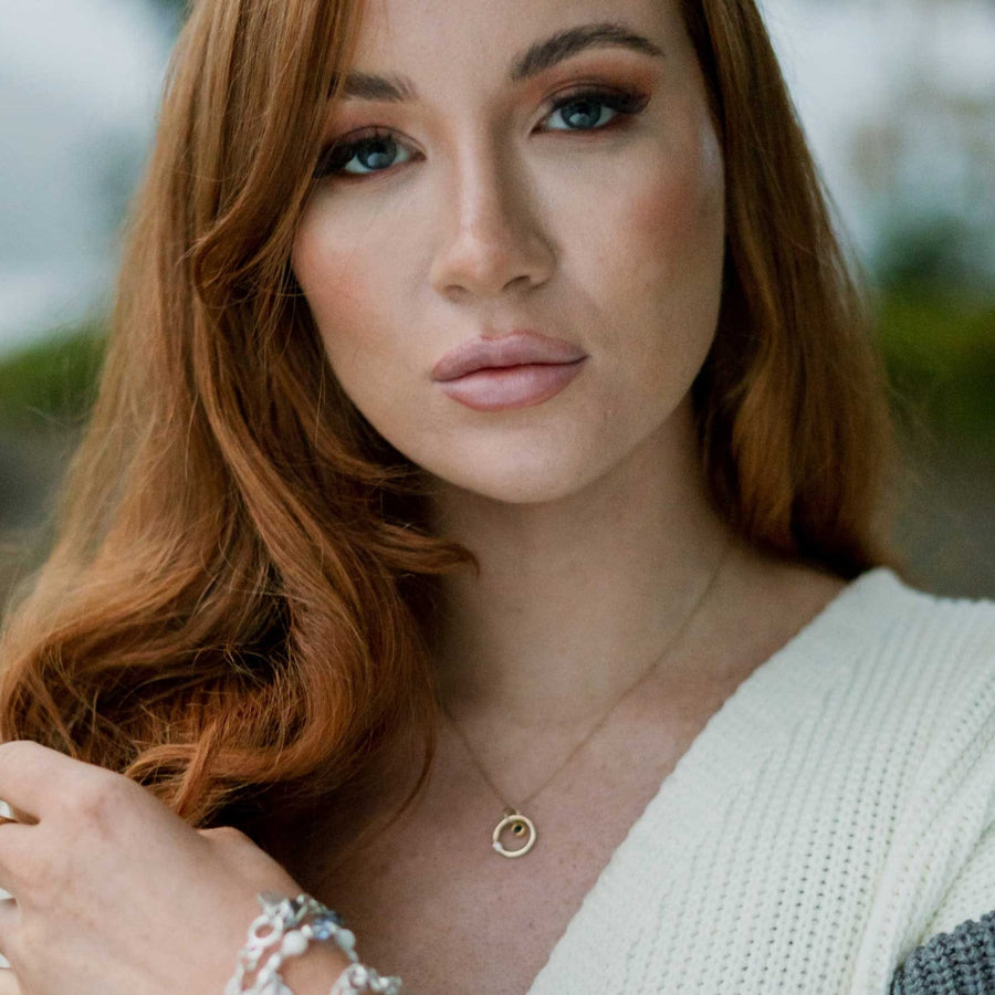 Solasta gold, diamond, sapphire pendant on gold chain being worn by girl.