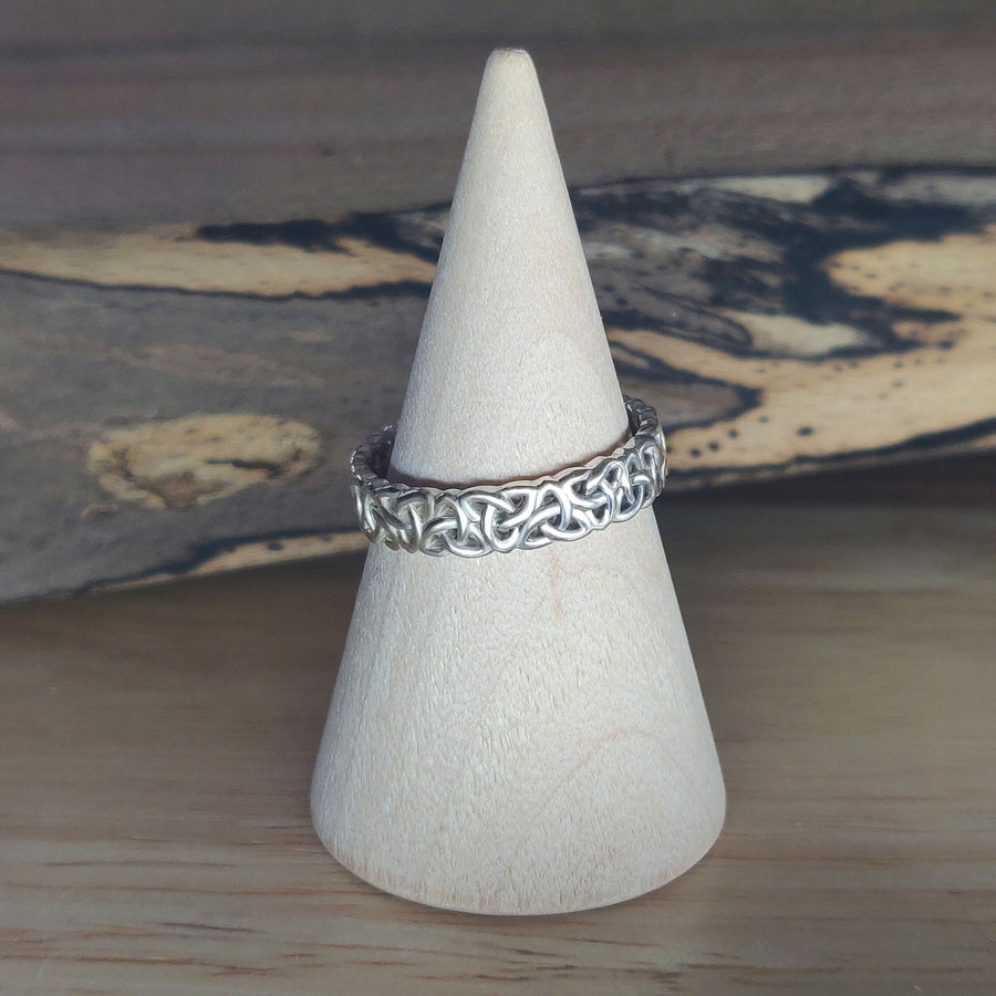 Ladies Triquetra Pattern Celtic Knot Wedding Ring on a wooden cone.