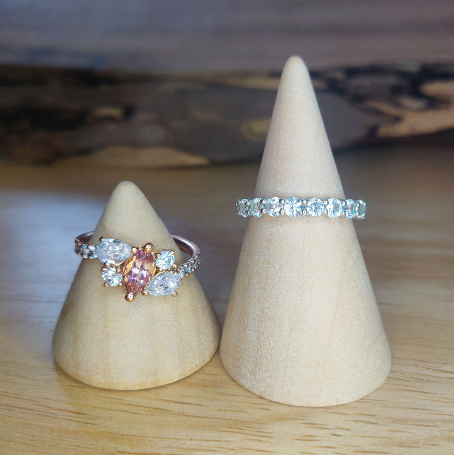 Bi Colour Tourmaline and lab-grown diamond gold engagement ring on a wooden cone, next to a gallery ring.