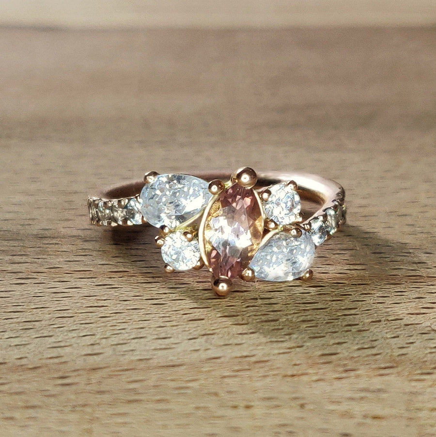 Bi Colour Tourmaline and lab-grown diamond gold engagement ring sitting on a wooden bench.