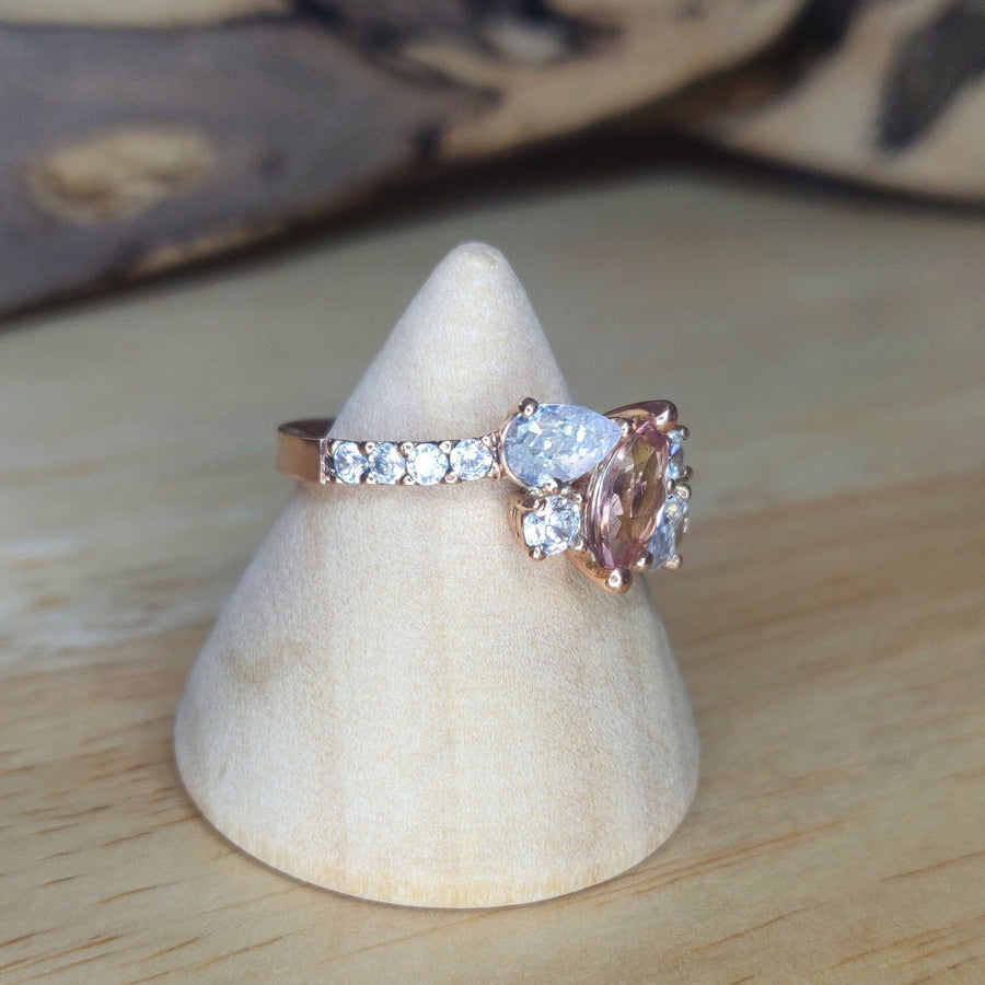 View of the Pavé shank setting of a Bi Colour Tourmaline and lab-grown diamond gold engagement ring on a wooden display cone.