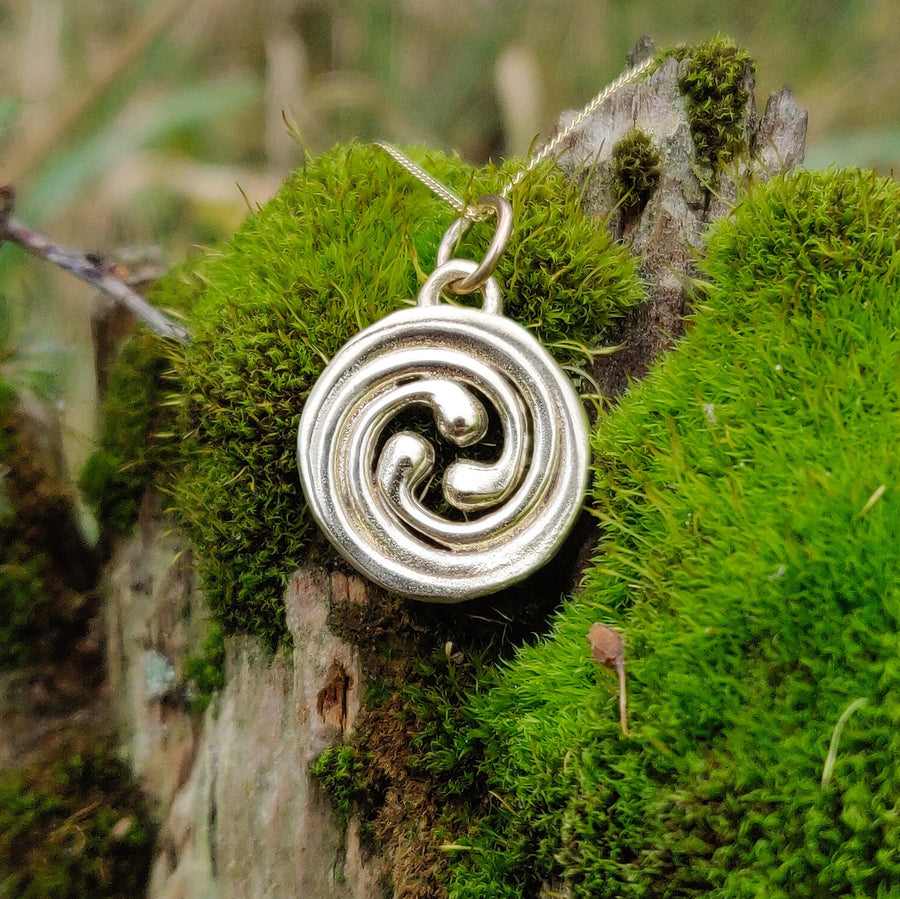 14k solid gold celtic spiral necklace in a nature setting.