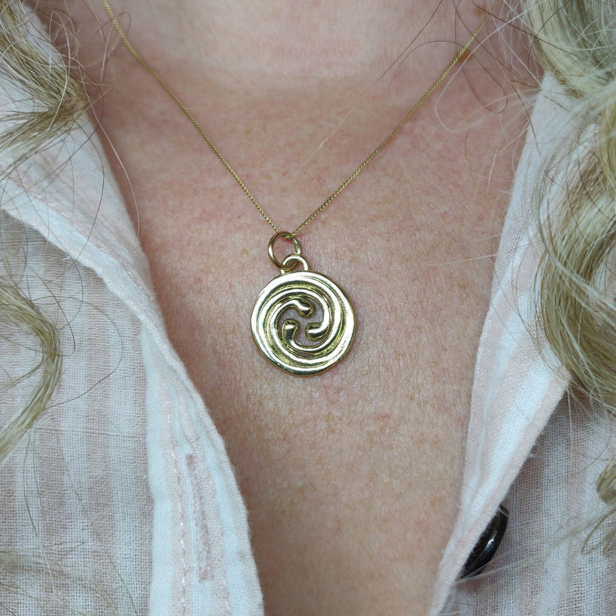 14ct gold celtic spiral knot pendant being worn.