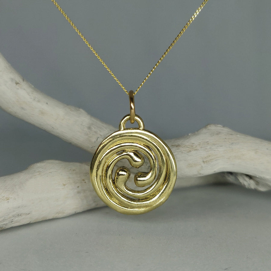 Solid gold celtic spiral pendant in 14ct gold, hanging from a chain against a white background.