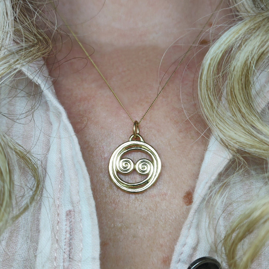14k solid gold yellow gold celtic pendant being worn.