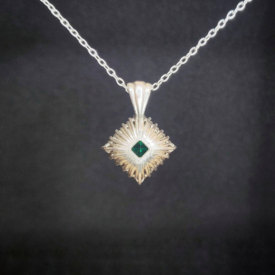 Rear View of a Princess Emerald and Diamond Cluster Necklace on a black background