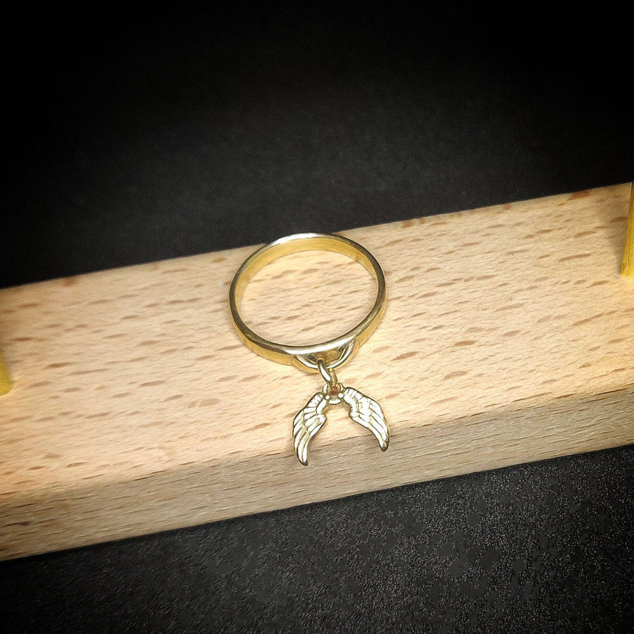 Angel Wings Charm ring on a wooden display