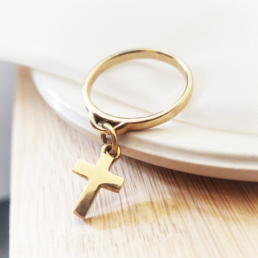 Gold Cross Charm Ring on a dish
