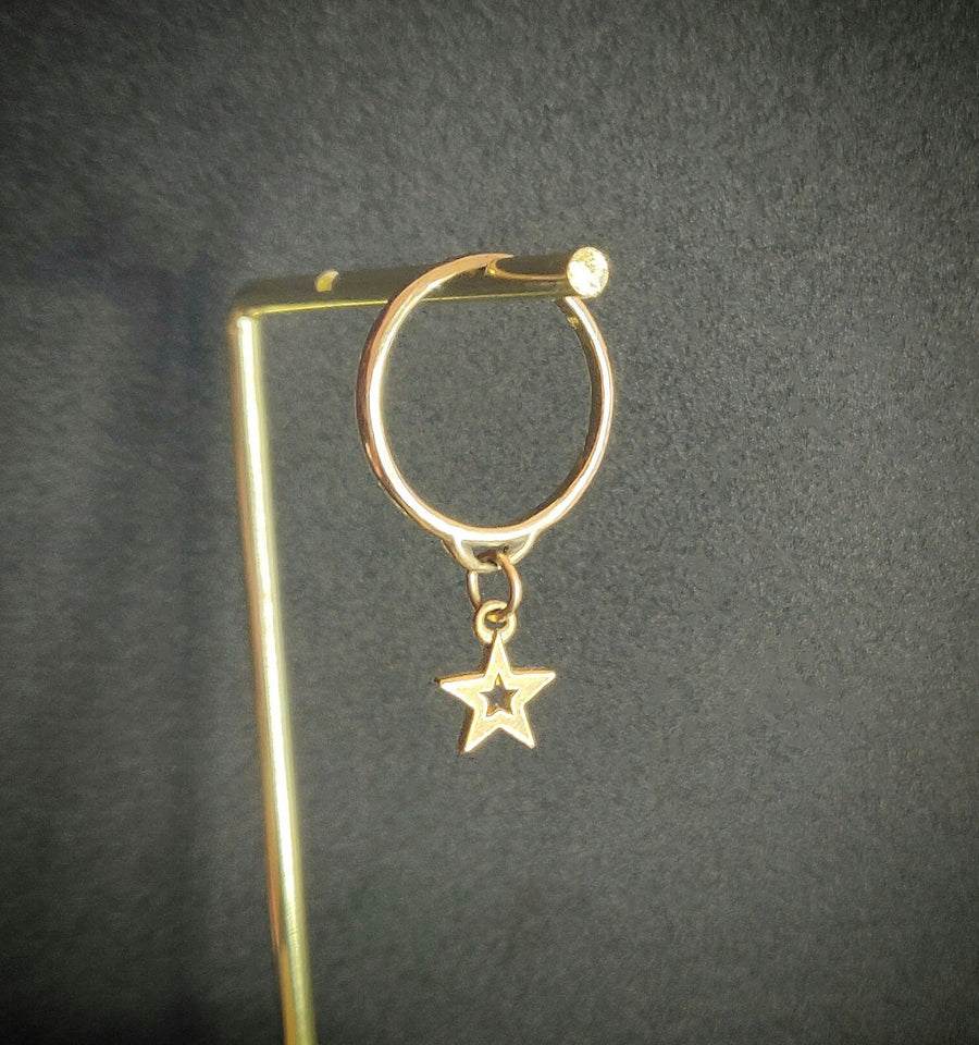 Gold star charm ring on a hanging display.