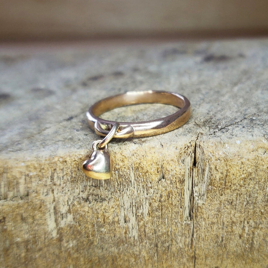 Gold Charm Ring with heart dangle charm on a wooden block