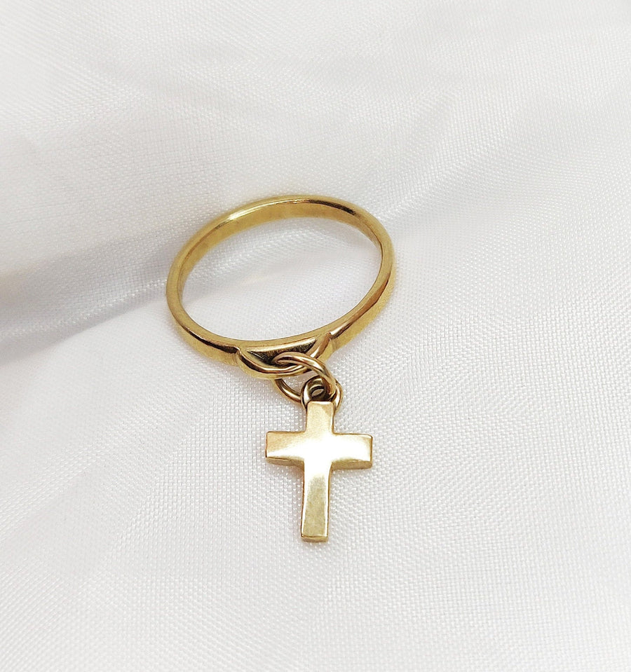 Gold cross ring on a white background.