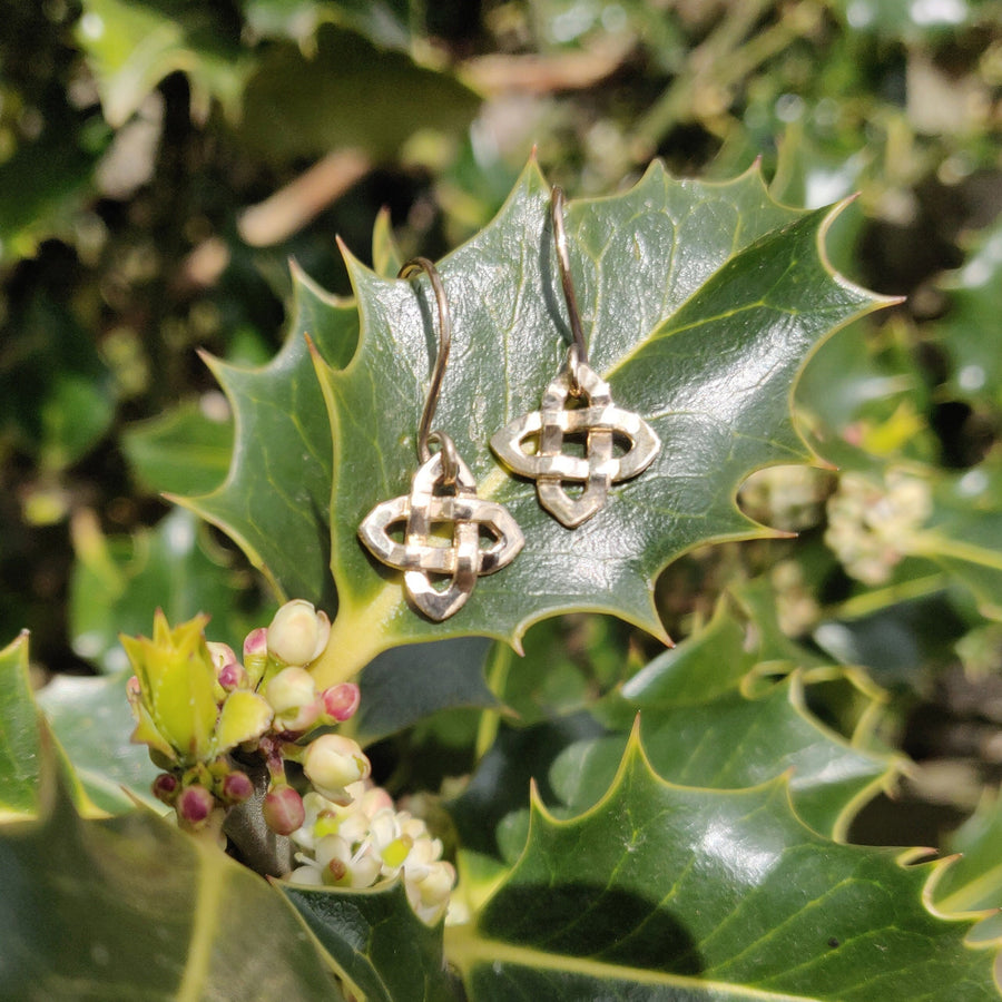 14k solid gold dangle earrings with celtic knot on a leaf.