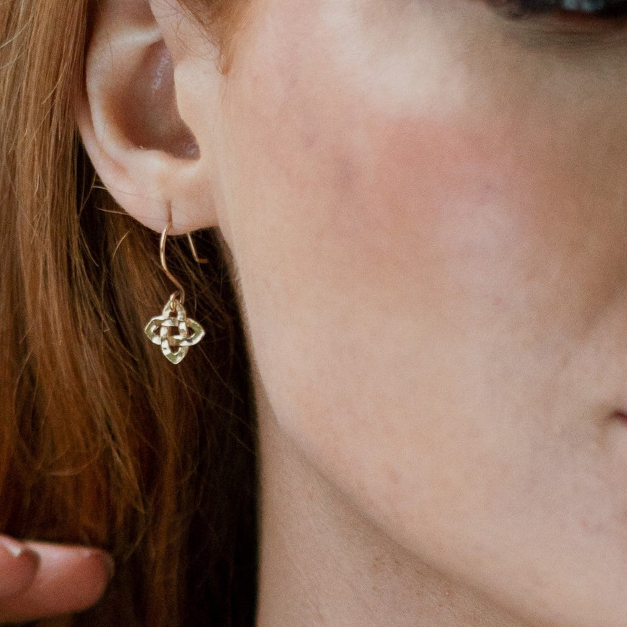 Model wearing a solid gold celtic knot earring.