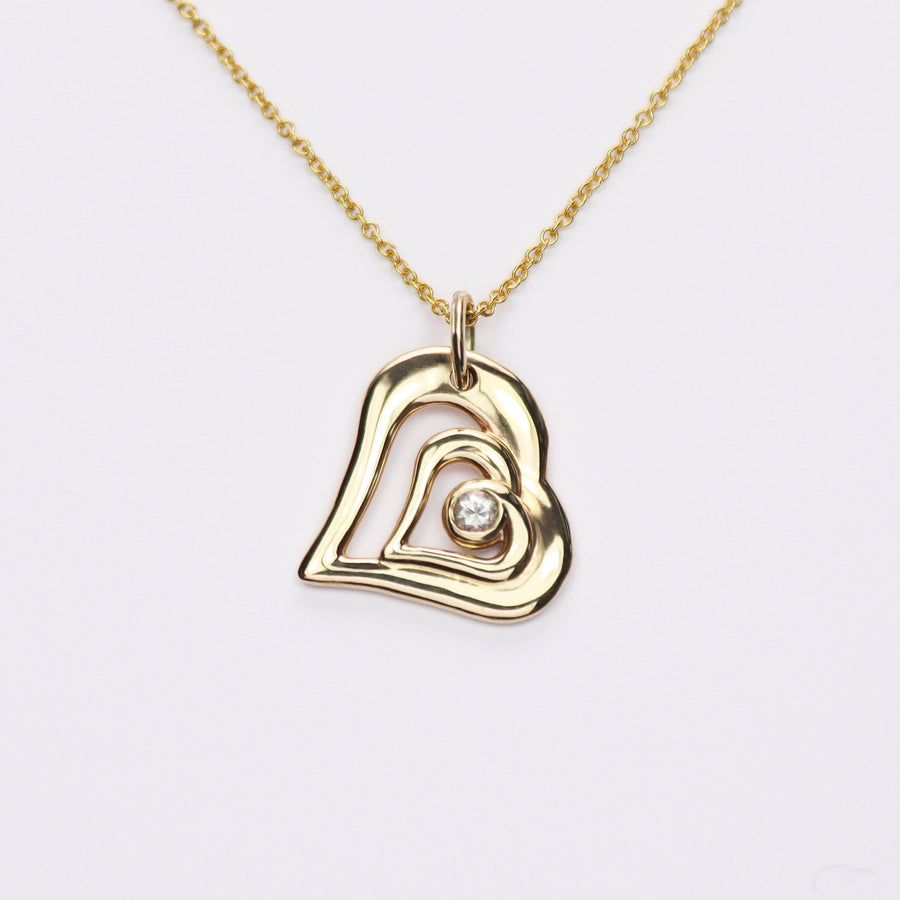 Acushla gold and diamond heart necklace on a white background.