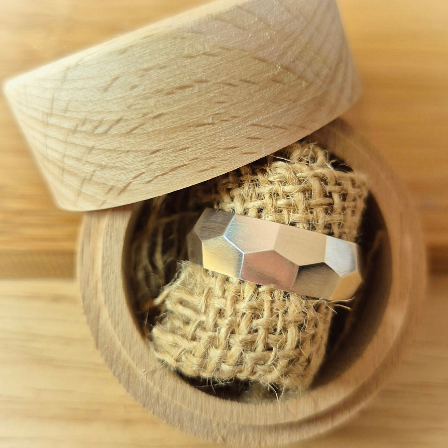 Round jewellery box containing an argentium silver chunky hex pattern ring.