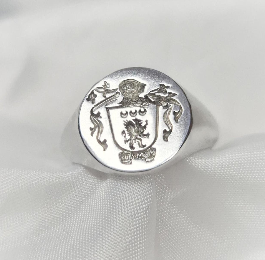 Wax seal signet ring made in argentium silver on white background.