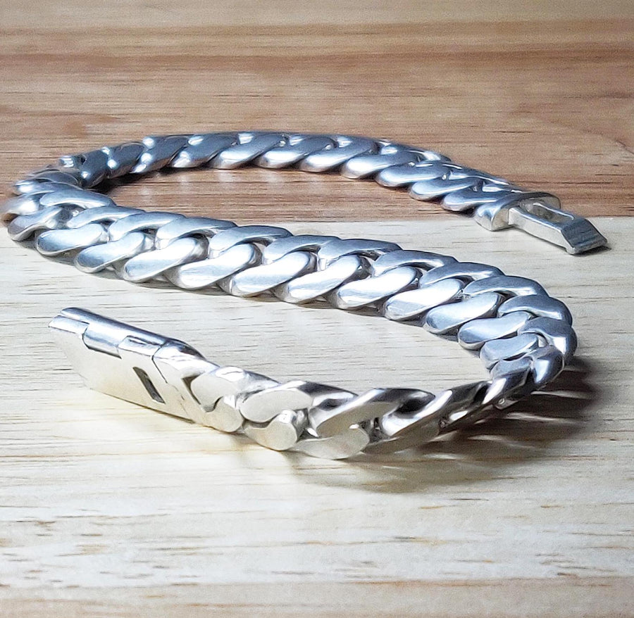 view of a cuban curb style bracelet in argentium silver on a bench.