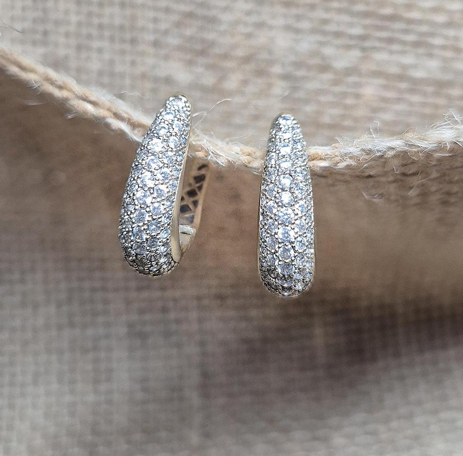 diamond pavé earrings hanging from a piece of cloth