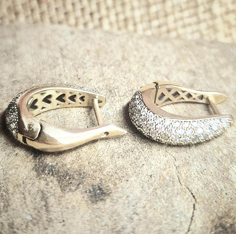 diamond pave gold earrings from two different angles on a wooden block