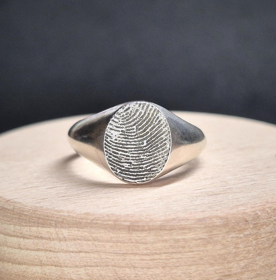 Silver fingerprint ring on a display box