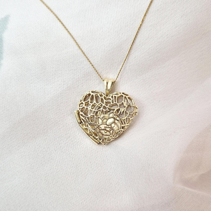 Sleepy Fox in a Hedgerow filigree heart locket necklace on fine gold chain, resting softly on white fabric background.