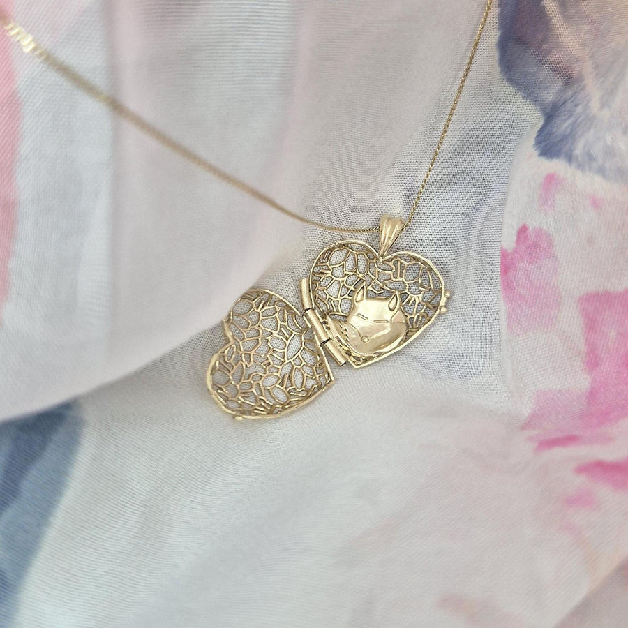 Open Sleepy Fox in a Hedgerow gold heart locket necklace revealing the tiny sleeping fox nestled inside, on soft pastel fabric.