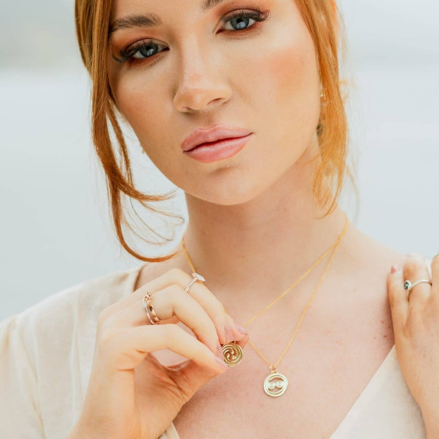 Girl wearing 2 gold celtic necklaces