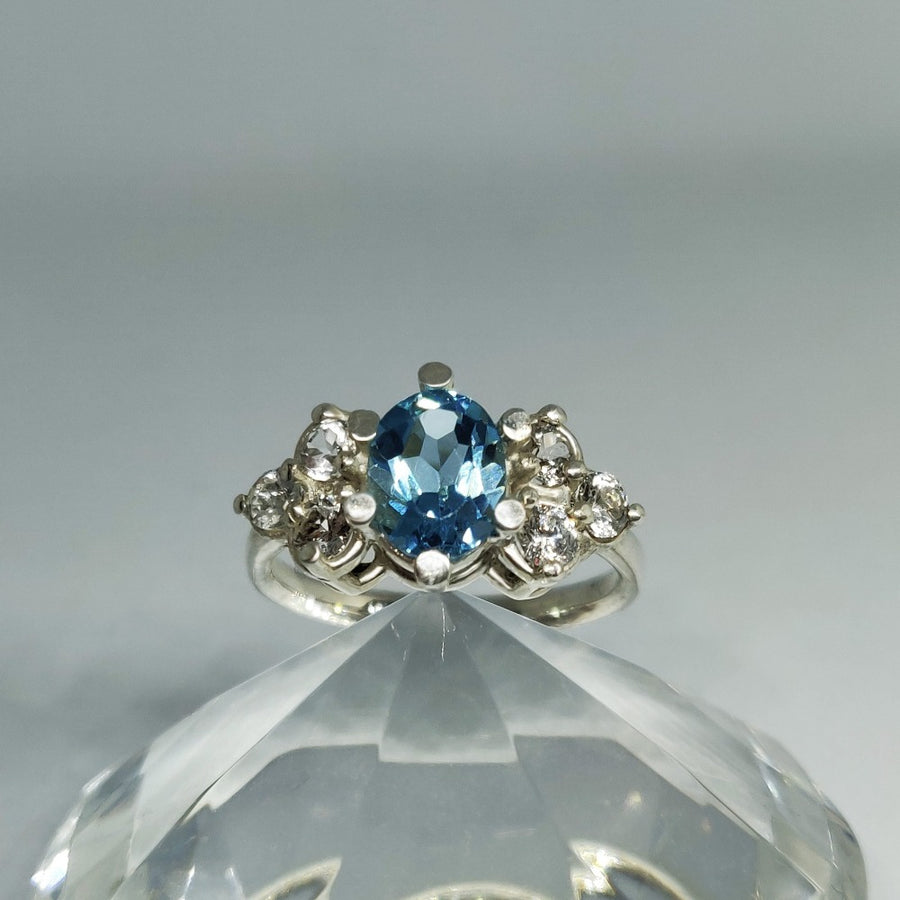 London blue topaz and white topaz argentium silver ring resting on a crystal base