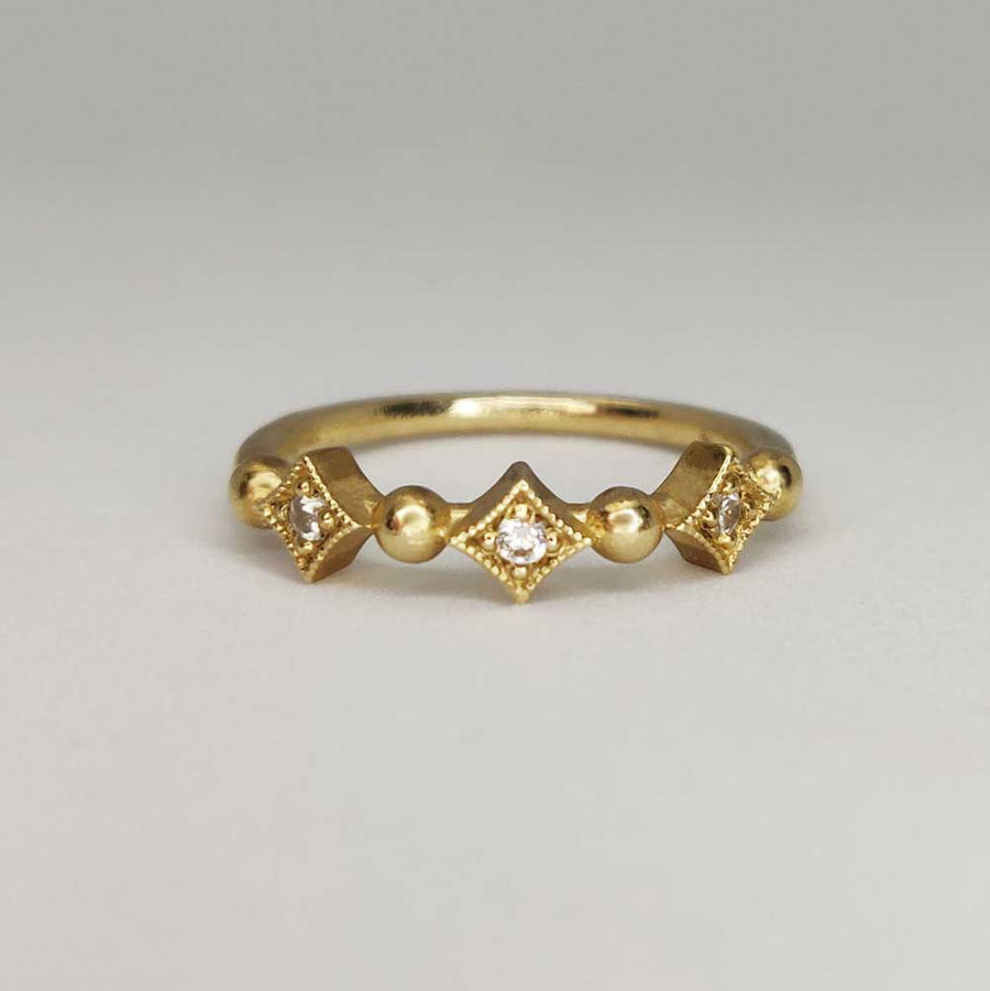 Gold milgrain ring with white sapphires on white background