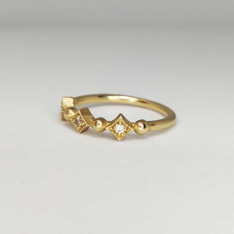 Gold milgrain ring with white sapphires from the side on white background