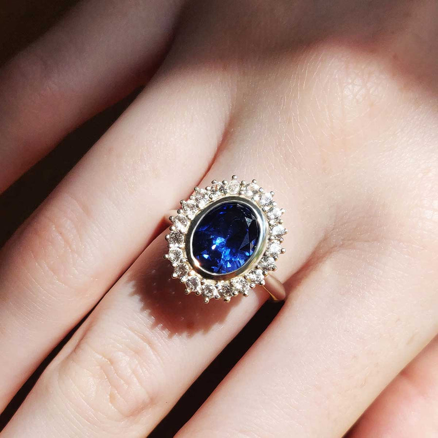 Blue and white sapphire cluster ring in argentium silver being worn
