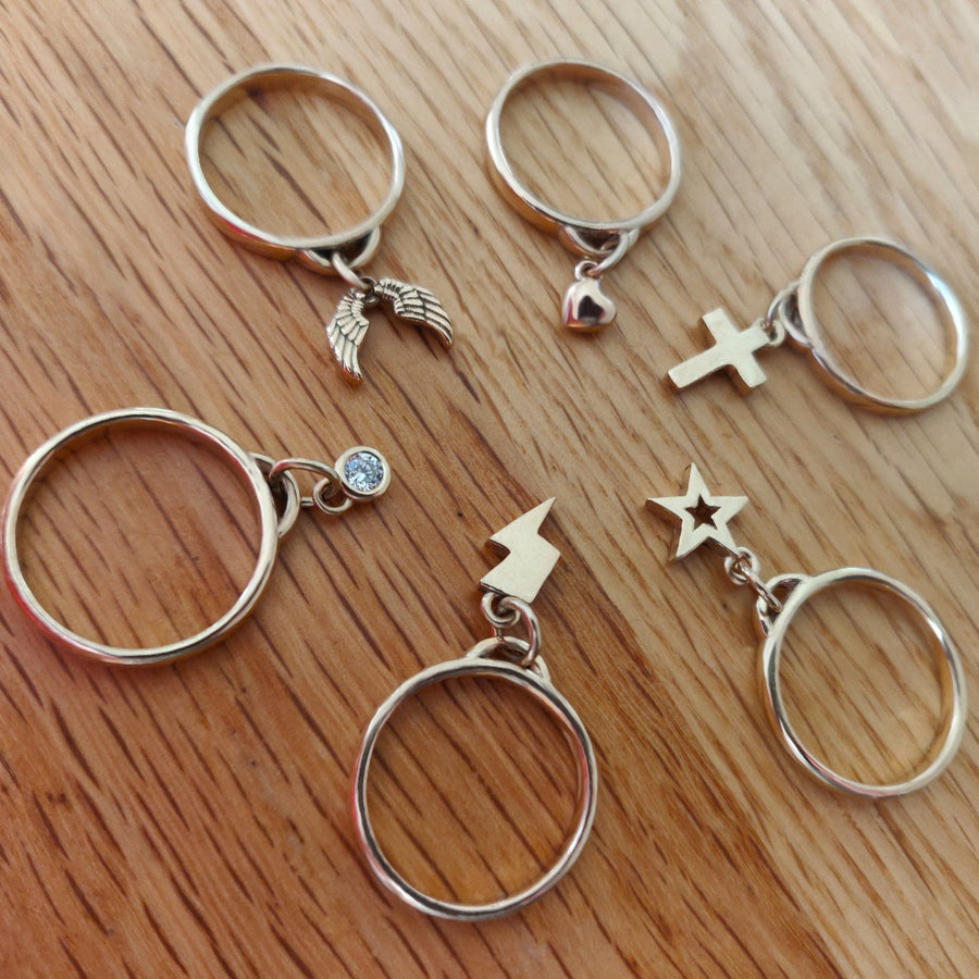 Selection of drop rings with various charms on a wooden background