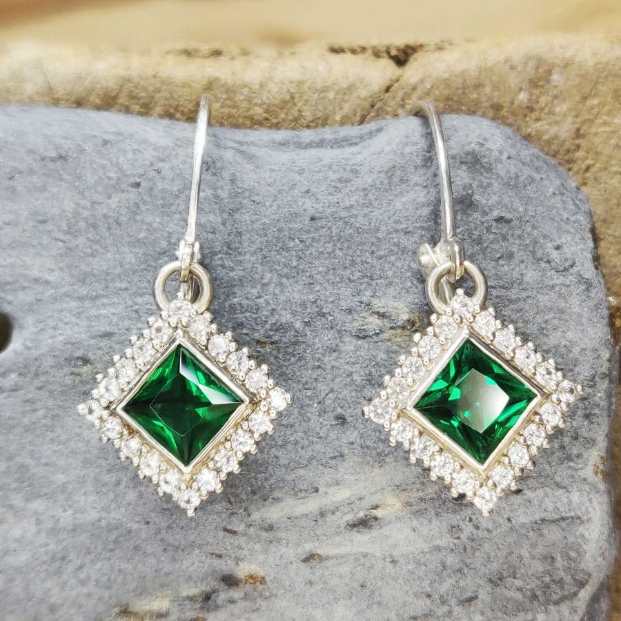 Princess cut emerald and white sapphire cluster earrings in argentium silver on slate background