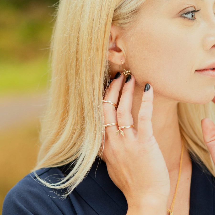 Blonde girl wearing angel wing charm ring and other jewellery