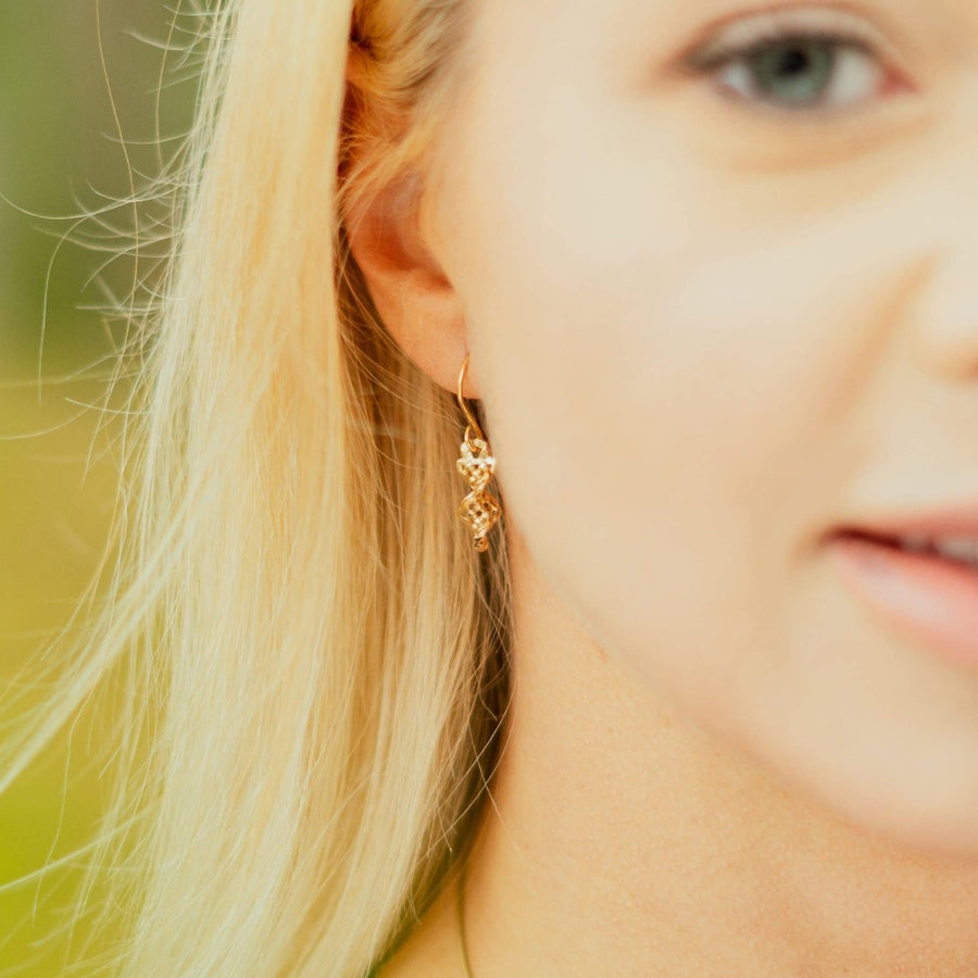 close up on girl wearing gold dirk handle twist celtic earring