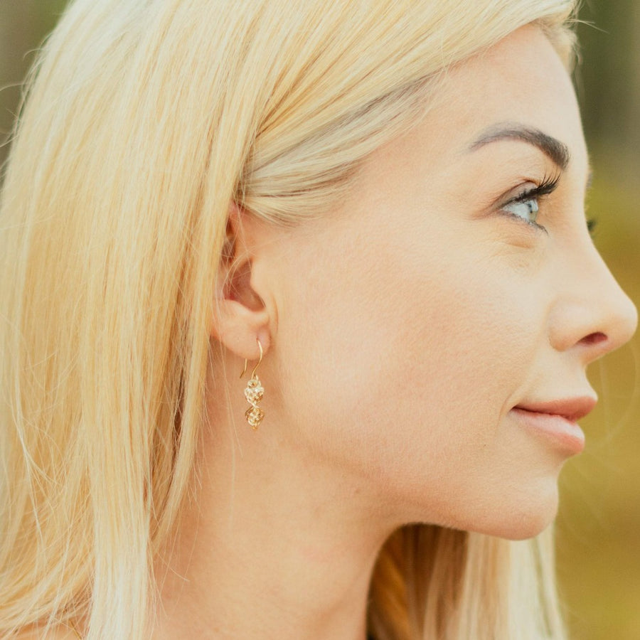 Girl wearing dirk handle twist gold celtic knot earring