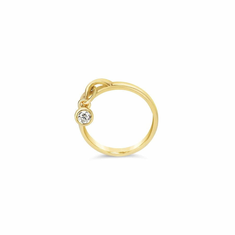 Gold drop ring with a diamond bezel charm on white background