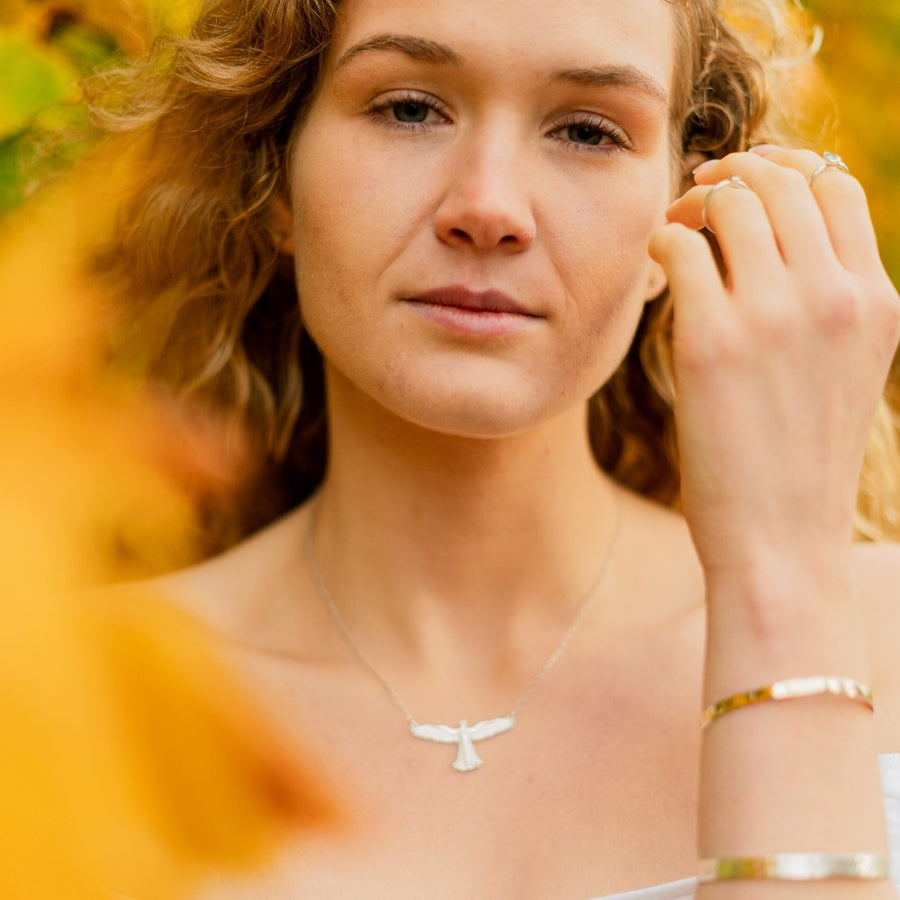Girl wearing guardian angel necklace and silver and gold bracelets