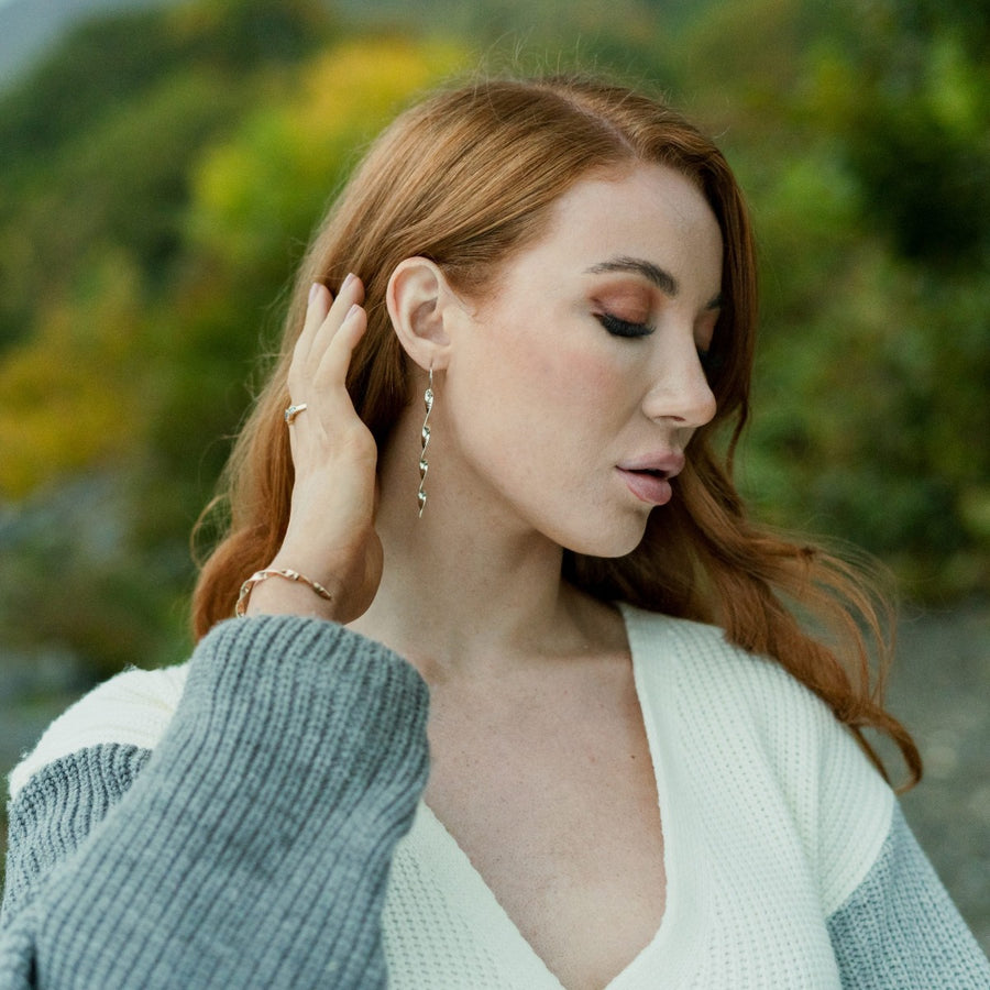 Girl in cardigan outdoors wearing Twisted argentium silver earrings