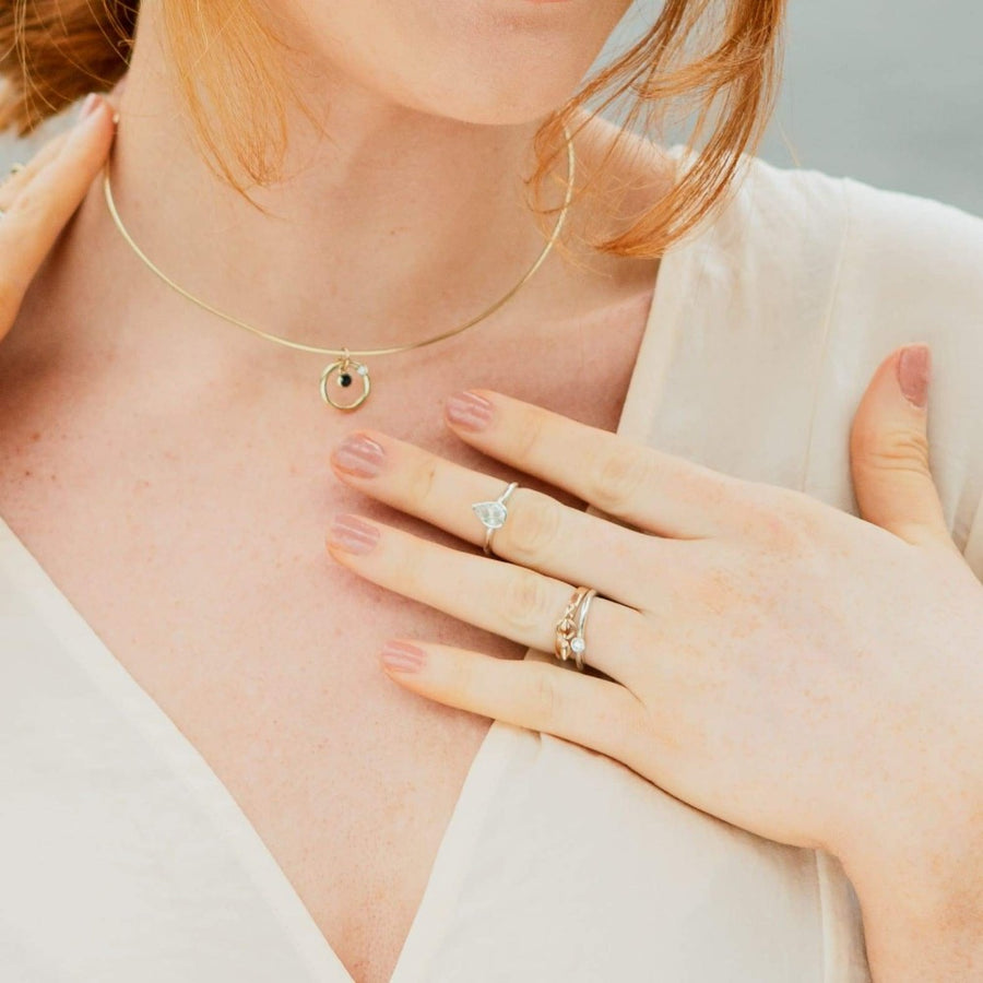 Girl wearing white pear cut topaz argentium silver ring and gold necklace